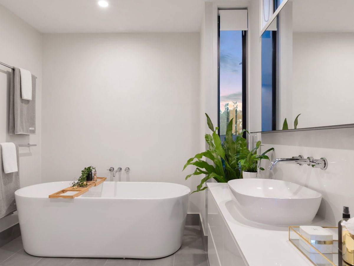 Baño con ducha de obra, mueble de lavabo suspendido y alicatado claro