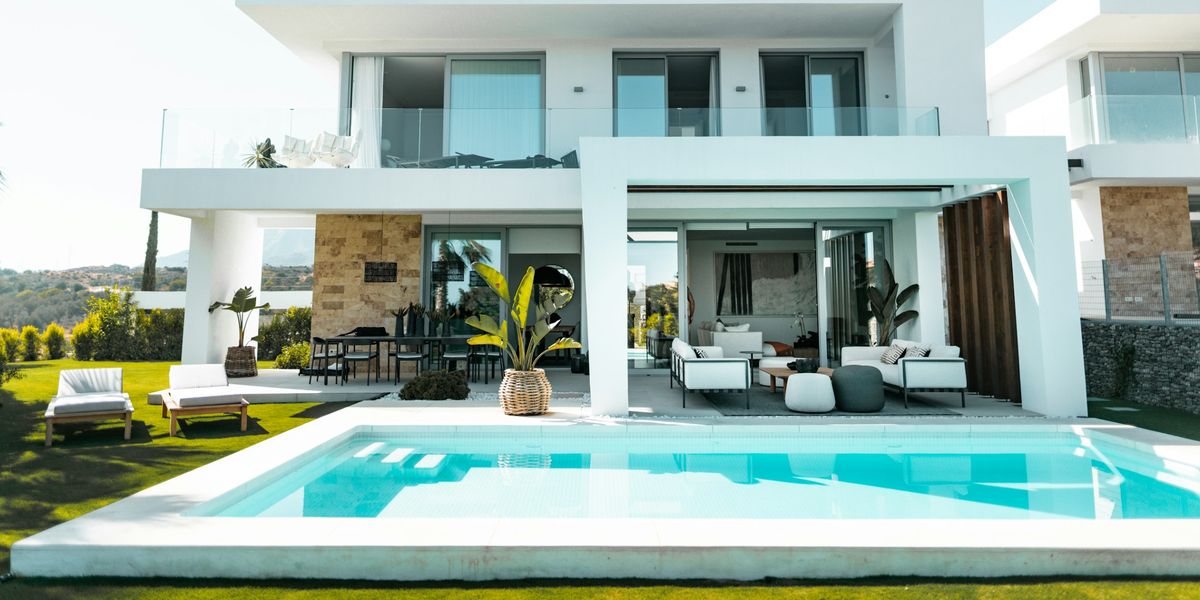 Piscina de obra en el jardín de un chalet de Mallorca, con coronación clara y solárium junto a la vivienda