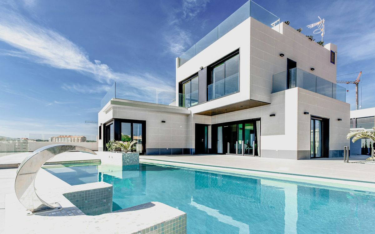 Chalet reformado en Mallorca visto desde el jardín: fachada blanca, grandes ventanales y piscina